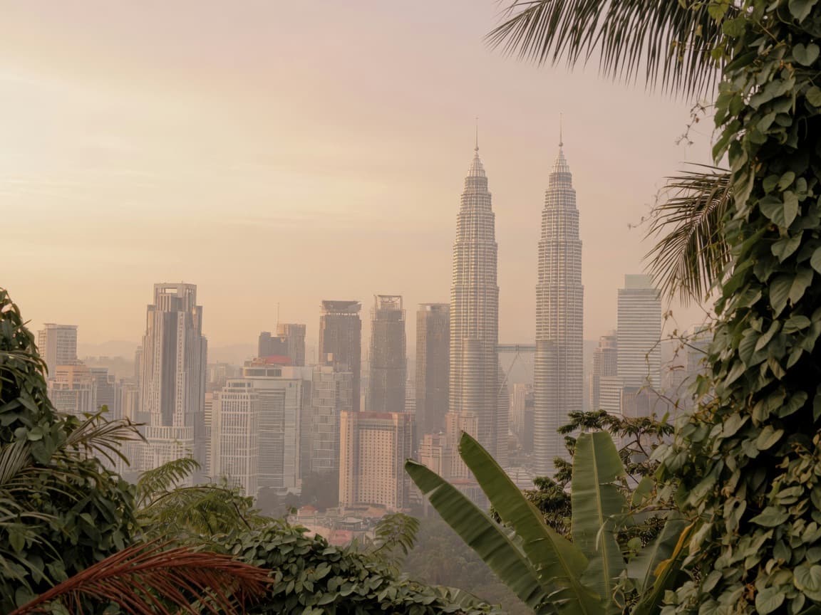 Kuala Lumpur skyline framed by tropical greenery